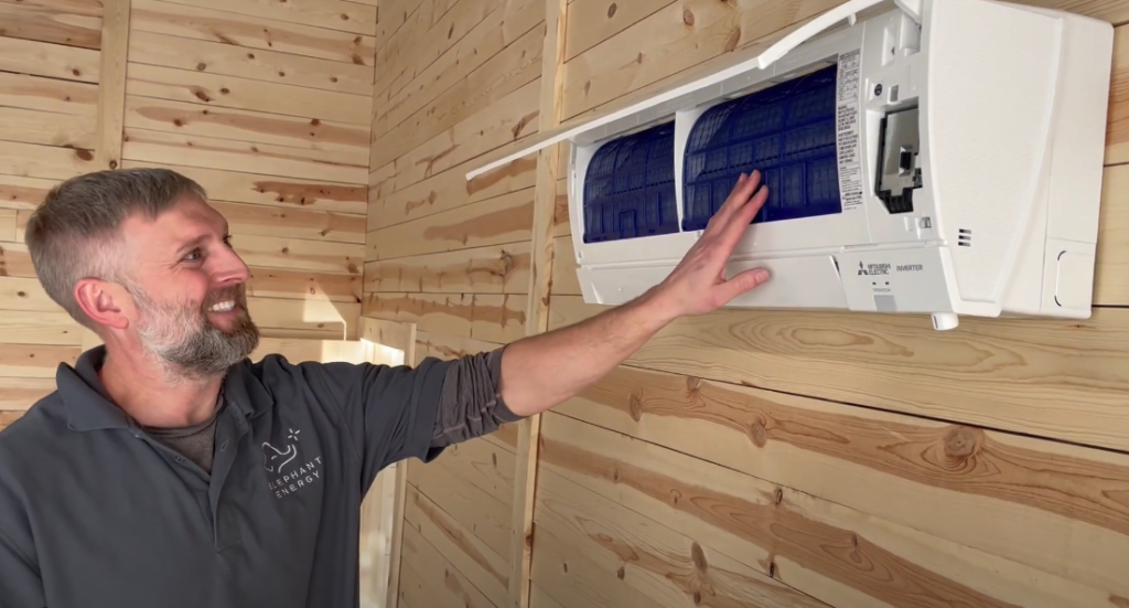 Elephant Energy technician demonstrating how to clean wall-mounted mini split heat pump filters during extreme heat maintenance